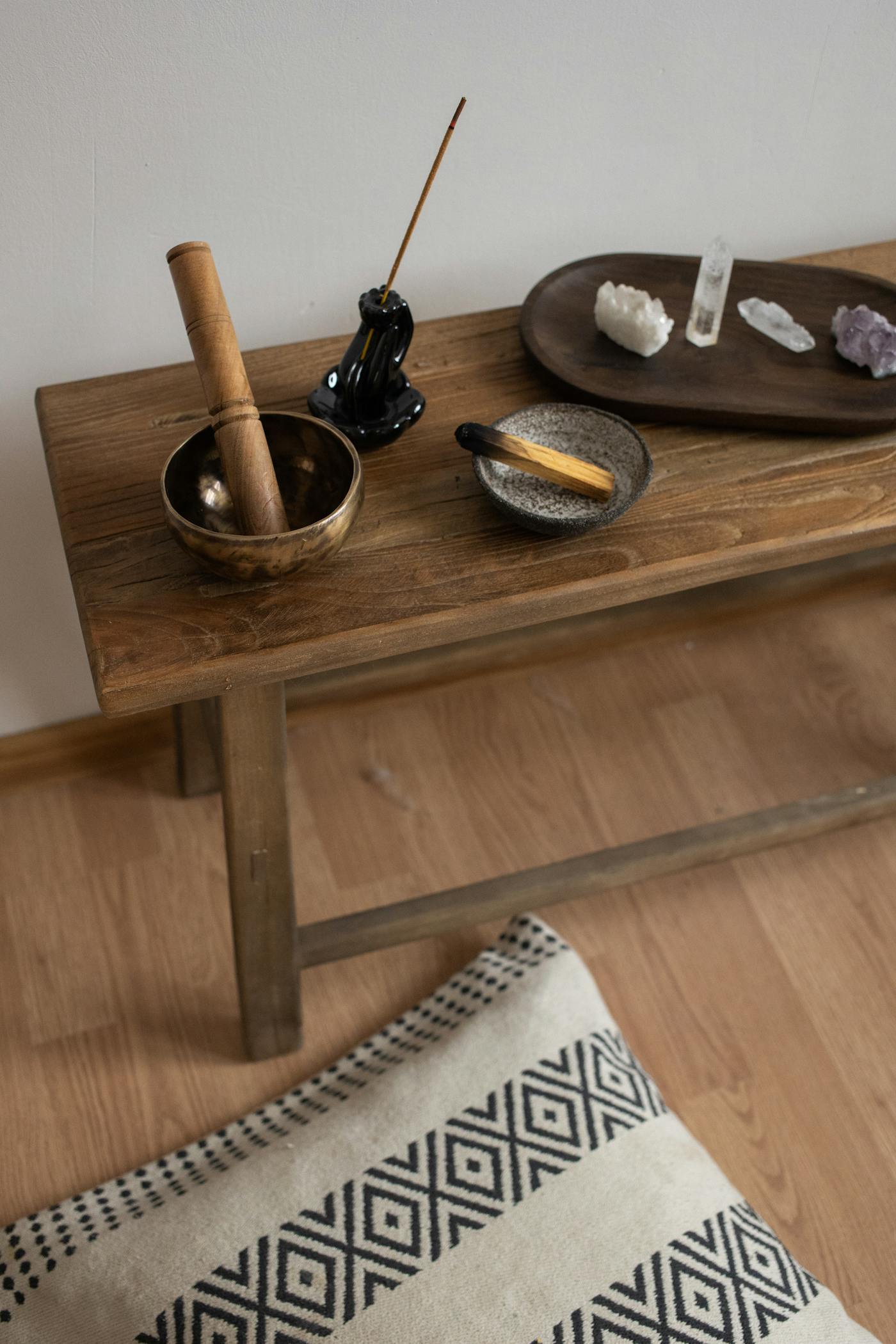 Singing bowl, incense, and crystals arranged for energy work